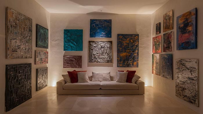 canapé beige avec coussins rouges et blancs dans un article sur comment trouver la meilleure œuvre abstraite pour vous
