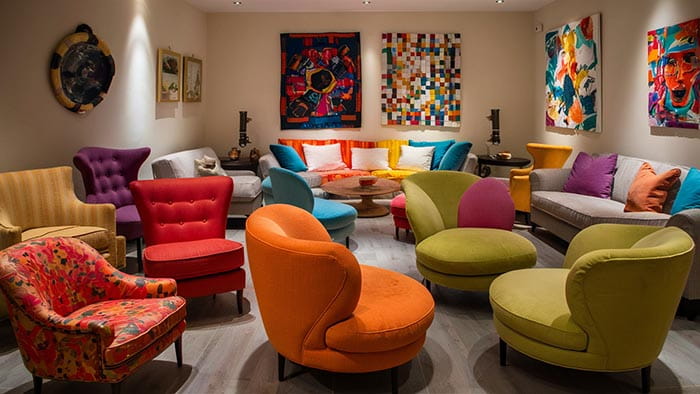 vibrant armchairs in bold orange and lime green colors surround a central coffee table in a trendy interior design setting
