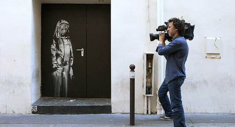 Street art-bilde inspirert av den tilslørte silhuetten malt på døren til Bataclan