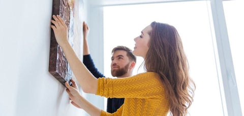 un tableau encadré sur toile avec un design abstrait texturé aux tons terreux suspendu à l’aide d’une ficelle